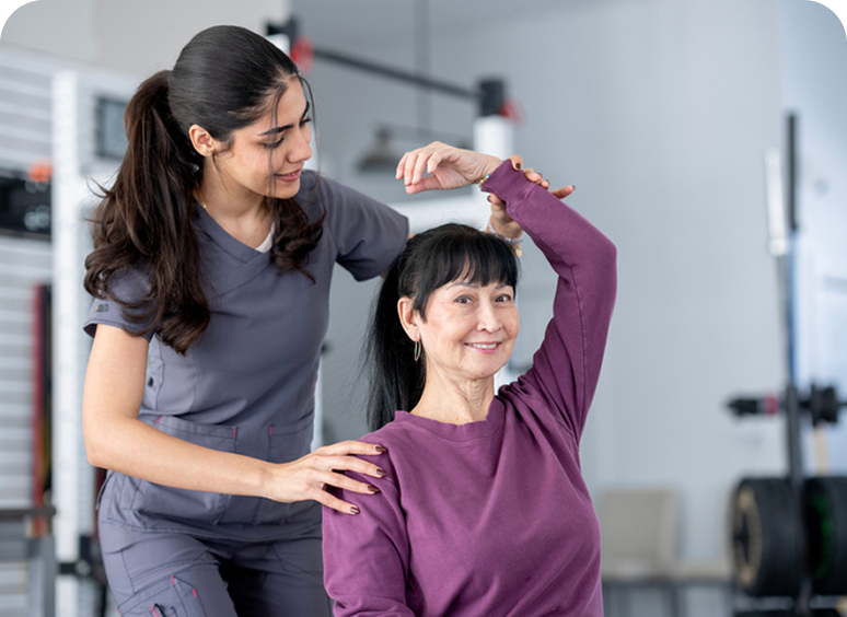 Physical therapist assisting woman with exercise.