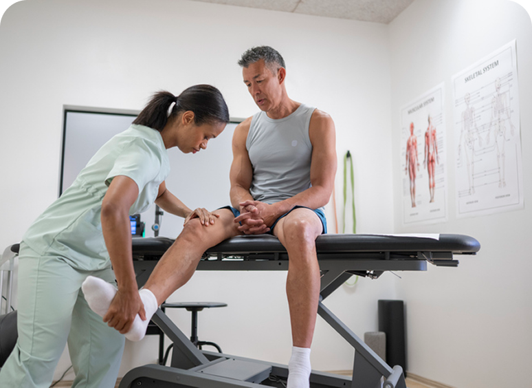 Physical therapist assisting patient with leg exercise.