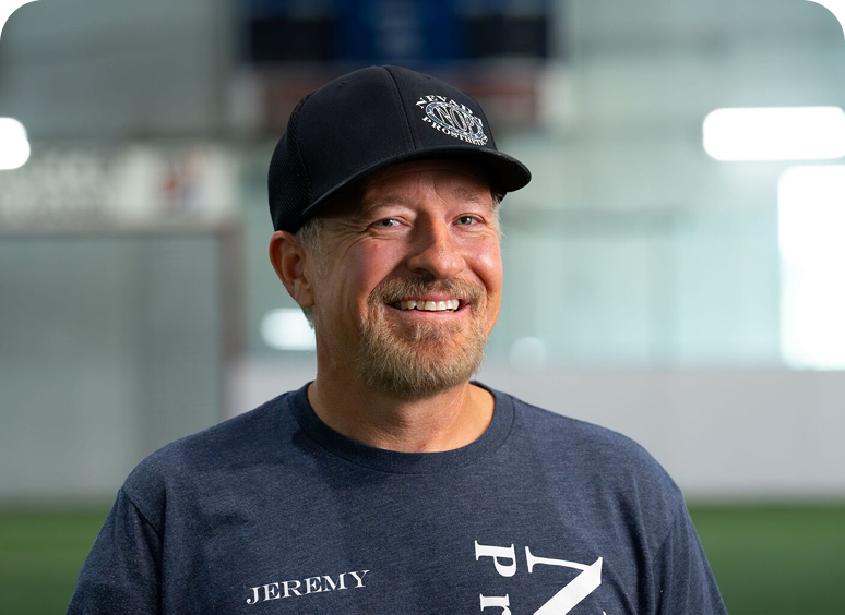 Man smiling wearing a cap indoors.