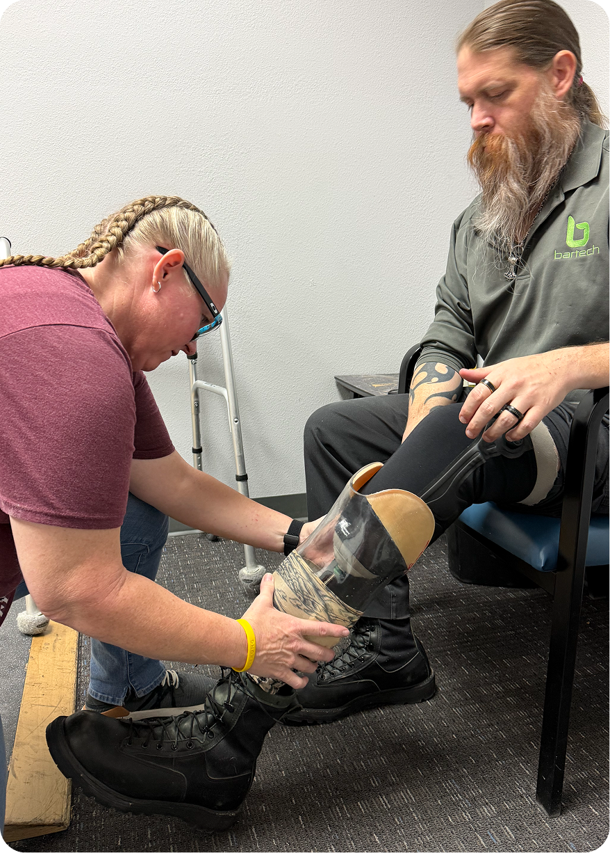 Man adjusting prosthetic leg with assistance.
