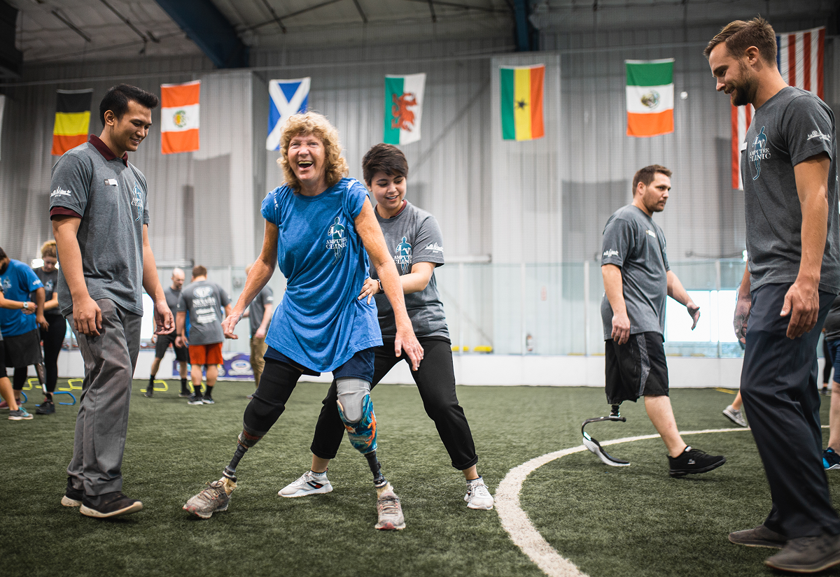 People playing soccer with prosthetic legs indoors.